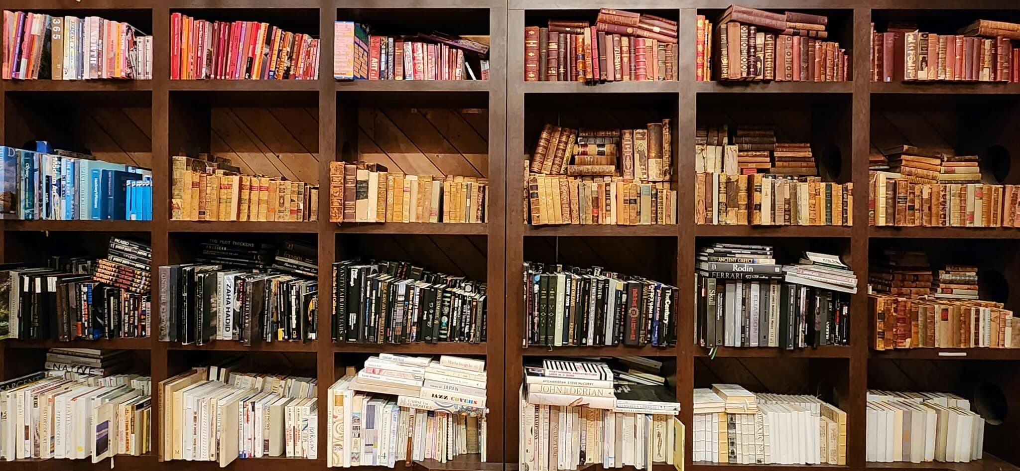 A full wooden bookshelf lined with legal and reference texts — representing the depth of reading, case research and structured knowledge required for VCE Legal Studies