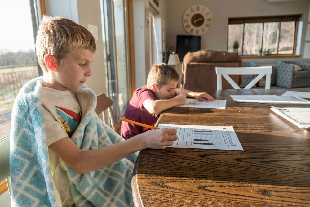 Two boys sitting at the table doing their homework.
